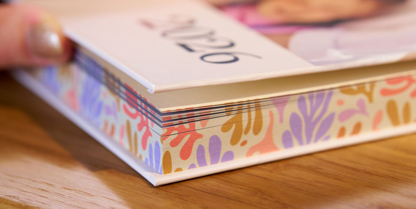 CEWE FOTOBUCH mit buntem Farbschnitt in Rosa, Orange, Gelb und Violett an den Seitenkanten
