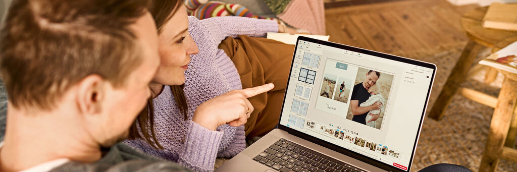 Frau und Mann bei der CEWE FOTOBUCH Gestaltung am Laptop