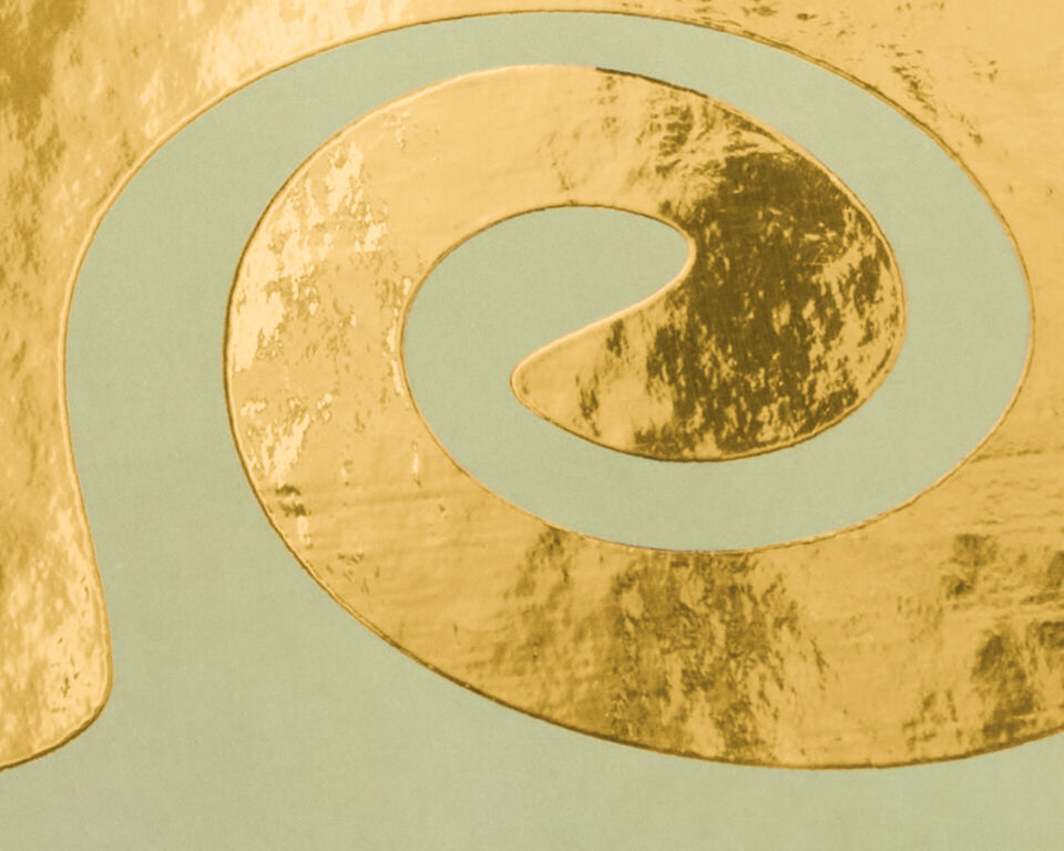 Spiralförmig geschwungene Goldveredelung auf mintgrünem Hintergrund.