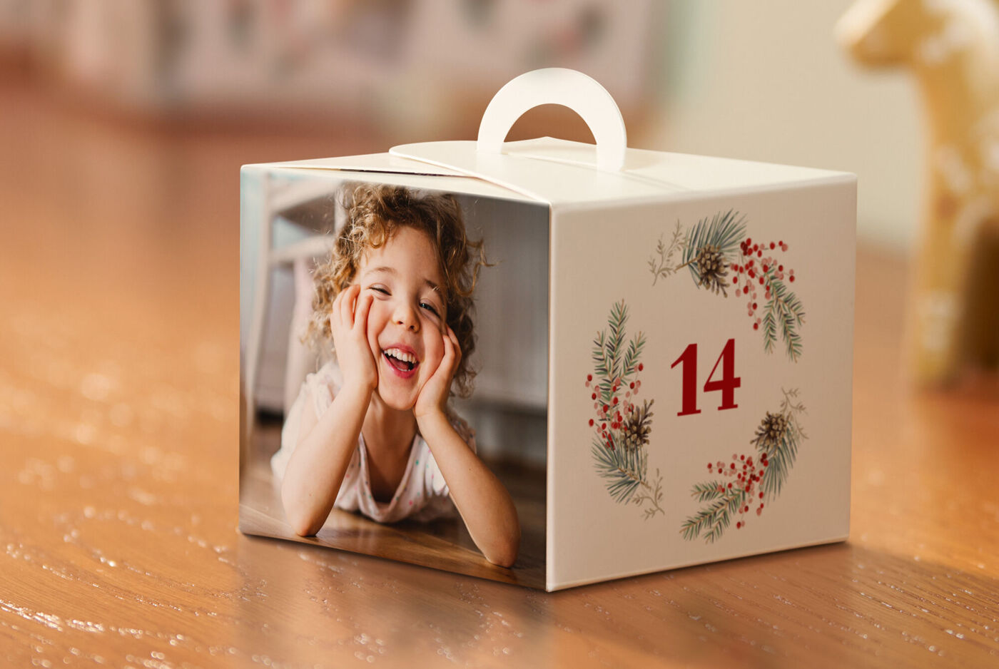 CEWE Adventskalender mit gestalteter Geschenkbox auf Holzkommode. Lichter und Dekoration