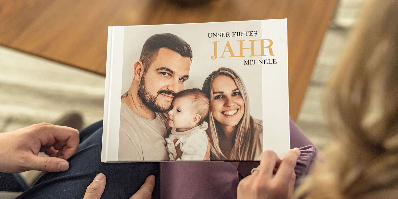 Blick über die Schulter: Sarah und Marcel Franke schauen sich gemeinsam ihr Jahrbuch an. Das Foto zeigt Sarah, Marcel und ihre Tochter Nele.