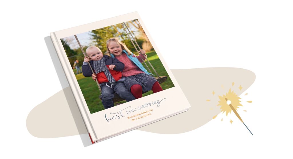 CEWE FOTOBUCH mit einem Bild von zwei Kindern auf einer Schaukel und mit dem Titel „Best memories“ mit Silberveredelung